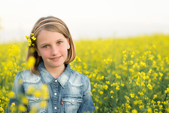 A beautiful blonde girl in a canola field